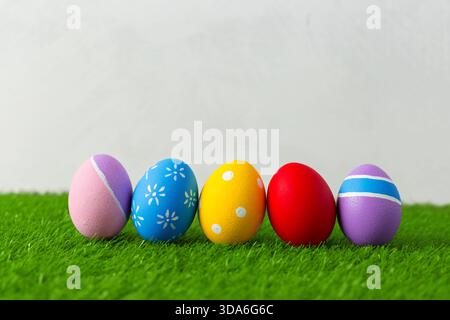 Brightly colored Easter eggs arranged on green grass in a spring setting Stock Photo