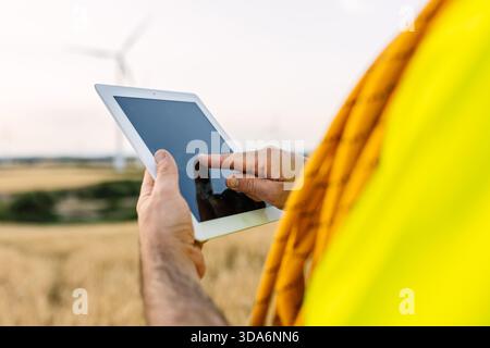 Engineer analyzing wind turbine performance using tablet Stock Photo