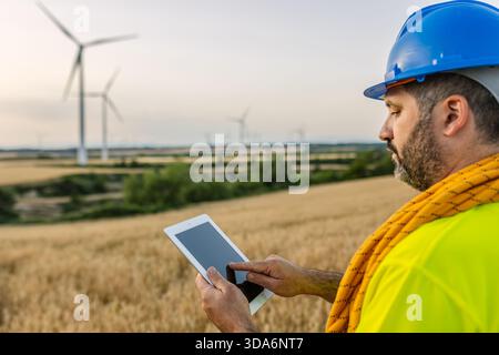 Engineer analyzing wind farm data on tablet Stock Photo