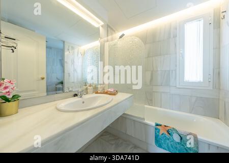 Spacious Bathroom Interior with Bathtub and Marble Tiles in mediterranean holiday home Stock Photo