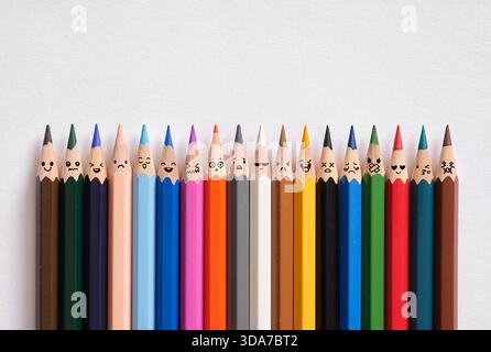 Line of colorful pencils showing various emotions drawn on their tips, representing diversity and collective feelings Stock Photo