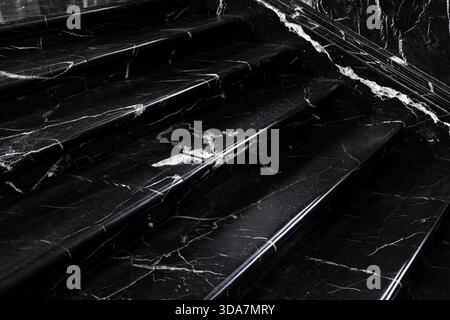 Close up polished black white marble stairs elegant texture bright veins creating dramatic contrast. Reflective surface adds depth subtle light Stock Photo