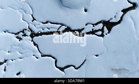 Aerial view of stark white snow contrasting against the dark earth in a textured landscape, Wildhaus-Alt Saint Johann, St. Gallen, Switzerland. Stock Photo