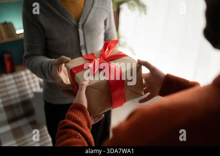 Male hands handing present box to senior man, close-up Stock Photo