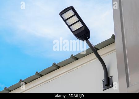 Solar light on concrete wall for to provide illumination around the road and walkway in the house with views of beautiful blue sky in the morning. Stock Photo