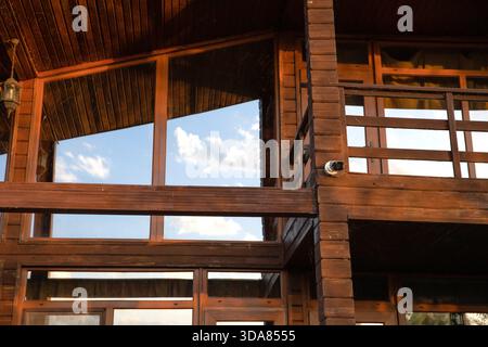 Wooden house exterior with security surveillance camera providing continuous property protection Stock Photo