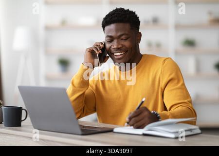 Happy black man freelancer working from home Stock Photo