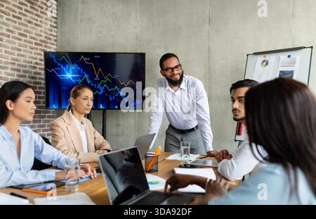 Diverse Team Collaborates in Modern Boardroom Focusing on Company Strategy Discussion Stock Photo