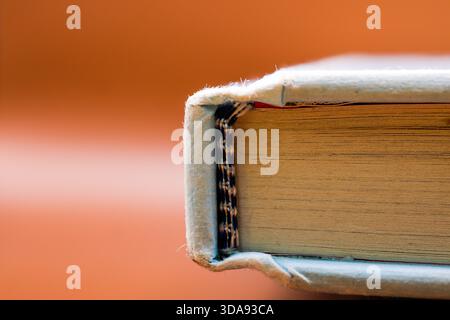 Macro close-up of an old book edge showing textured pages and worn hardcover. Stock Photo