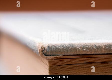 Macro close-up of an old book edge showing textured pages and worn hardcover. Stock Photo