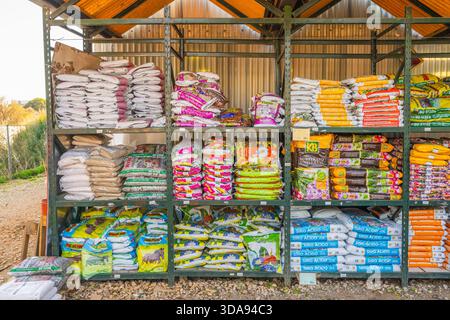 Tavira, Portugal, November 28, 2025.  Variety of colorful garden fertilizers and soil products are neatly arranged on shelving at a garden supply area Stock Photo
