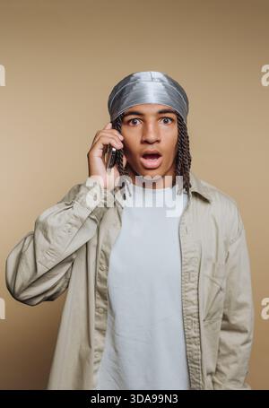 Young man with surprised expression talking on phone. Stock Photo