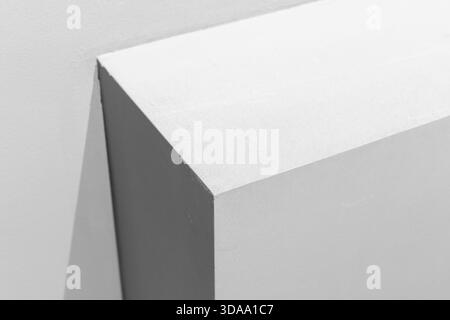 Monochrome closeup photo of a corner highlighting sharp angles, clean surfaces, and dramatic shadows. The minimalist composition conveys modern design Stock Photo