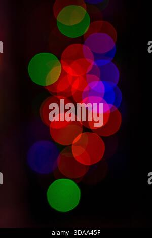 Vibrant bokeh lights in a vertical column of colorful circles forming an abstract glow Stock Photo