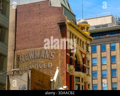 Melbourne, VIC, Australia. December 09, 2025. - A bright daytime view of contrasting urban architecture on Elizabeth Street, revealing an old brick wa Stock Photo