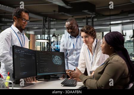 Team of technicians in office automating repetitive tasks using AI scripts on PC. Teamworking startup colleagues use artificial intelligence tech on computer to speed up feature implementation Stock Photo