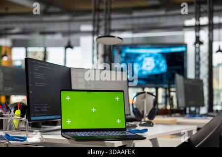 Green screen laptop in AI tech company workspace used to conduct code reviews and fix bugs. Mockup notebook on office desk used to design and implement deep learning algorithms Stock Photo