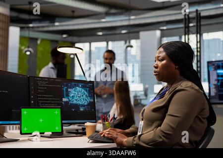 Admin writing code snippets on chroma key tablet in modern office, adjusting program configurations. Woman running diagnostic tools app on isolated screen device, monitoring API cloud services Stock Photo