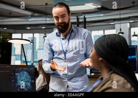 Smiling colleagues working together, adjusting deep learning algorithms parameters to automate tasks. Upbeat tech company coworkers doing brainstorming, using AI insights for code optimization Stock Photo