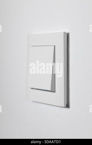 White light switch on a white wall, minimalistic design Stock Photo