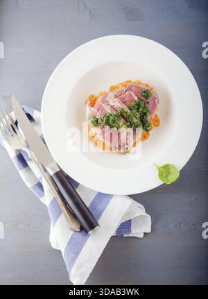 A plate of sliced roast beef, pumpkin and salsa verde Stock Photo