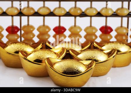 A gold ingot and abacus closeup Stock Photo