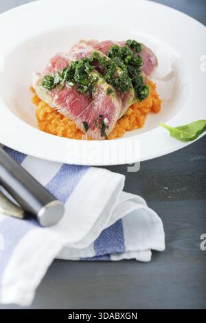 A plate of sliced roast beef, pumpkin and salsa verde Stock Photo