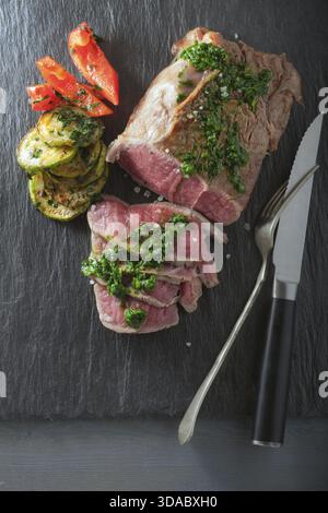 Roast Beef dinner with roasted zucchini, pepper and salsa verde Stock Photo