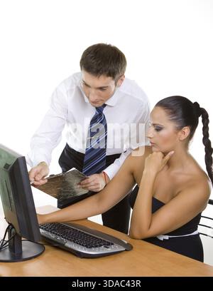 Two contemporary businesspeople discussing while working at the computer Stock Photo