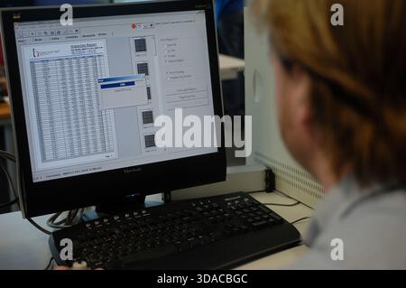 Workers guiding a computed guided lathe in an engineering factory. Stock Photo