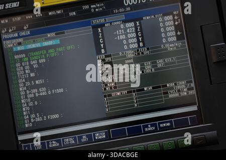 Workers guiding a computed guided lathe in an engineering factory. Stock Photo
