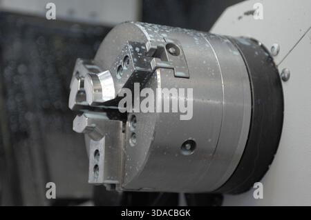 Workers guiding a computed guided lathe in an engineering factory. Stock Photo