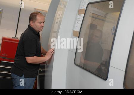 Workers guiding a computed guided lathe in an engineering factory. Stock Photo