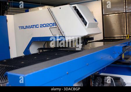 Workers guiding a computed guided lathe in an engineering factory. Stock Photo
