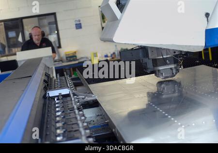 Workers guiding a computed guided lathe in an engineering factory. Stock Photo