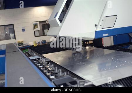 Workers guiding a computed guided lathe in an engineering factory. Stock Photo