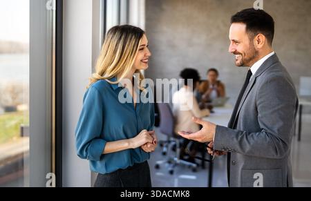 Two happy diverse multiethnic business team people working, talking in corporate office Stock Photo