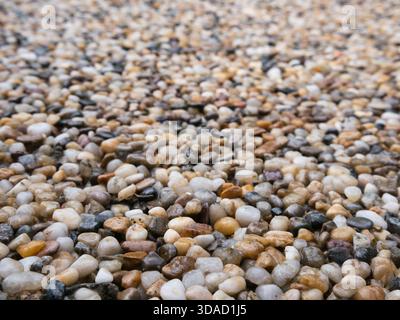 Detailed close-up of tiny pebbles viewed at an angle. Natural textured surface creating an interesting background for photography Stock Photo