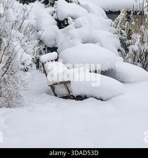 A thick blanket of snow has completely buried the garden chairs, turning the patio furniture into soft white sculptures.Photo by Willy Matheisl Stock Photo