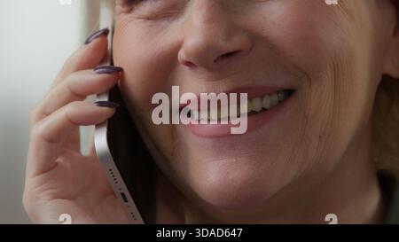Half face female mouth smiling old Caucasian woman talking mobile phone call conversation glad satisfied friendly talk speaking with smartphone Stock Photo