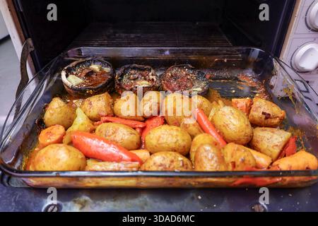 Rustic homemade dish with roasted baby potatoes, carrots, red peppers and seasoned portobello mushrooms Stock Photo