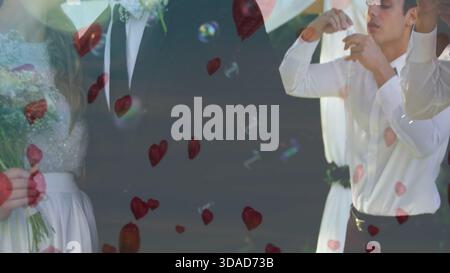Bridal couple and attendant standing in flat design wedding with bouquet, rose petals, soap bubbles Stock Photo