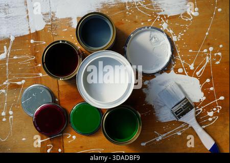 Tin cans with paint on old wooden Stock Photo