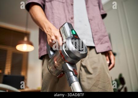 Man Using Cordless Vacuum Cleaner for House Cleaning Stock Photo