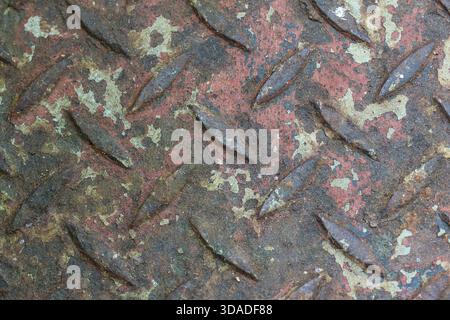 Rusty metal diamond plate texture background showing grunge industrial pattern. weathered, corroded surface reveals heavy decay and rough, abstract fe Stock Photo