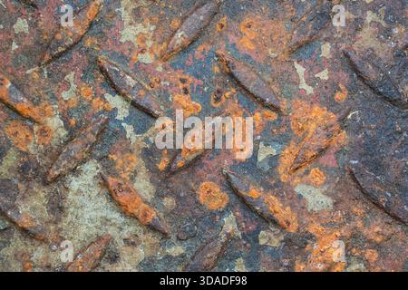 Close up of rusty metal diamond plate texture. This old industrial surface shows corrosion and decay, creating gritty and weathered background with se Stock Photo