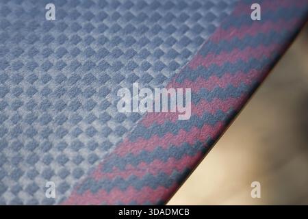 Modern gray abstract background of woven fabric texture with repeating geometric pattern. This durable textile has contrasting red and blue diagonal s Stock Photo