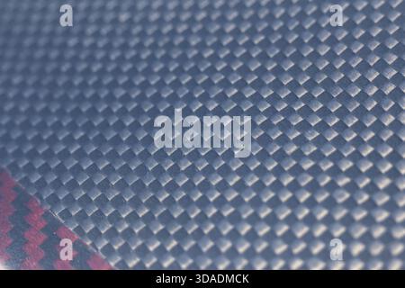 Macro close up of modern carbon fiber texture. This dark grey synthetic pattern serves as an industrial background with sleek, futuristic, and abstrac Stock Photo