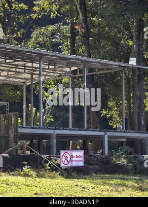 Building under construction with metal frame and no entry sign in forest. This outdoor structure in restricted area conveys sense of prohibition and q Stock Photo