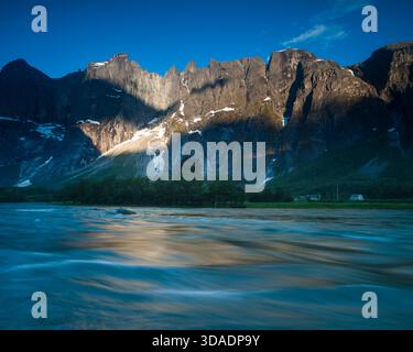 Early summer morning sunlight on the 3000 feet vertical Troll Wall  and the peaks Trolltindan in Romsdalen valley, Møre og Romsdal fylke, Norway. Stock Photo